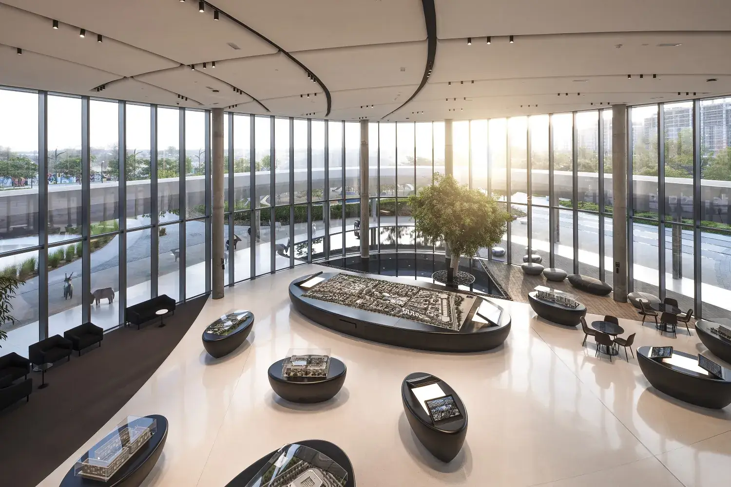 A sunlit sales gallery with architectural masterplan models