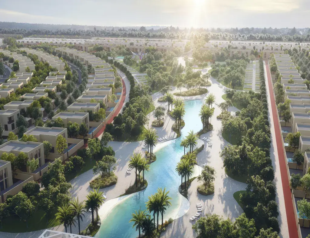 Aerial view of villas around a landscaped lagoon and palm-lined park in Hayyan, Sharjah