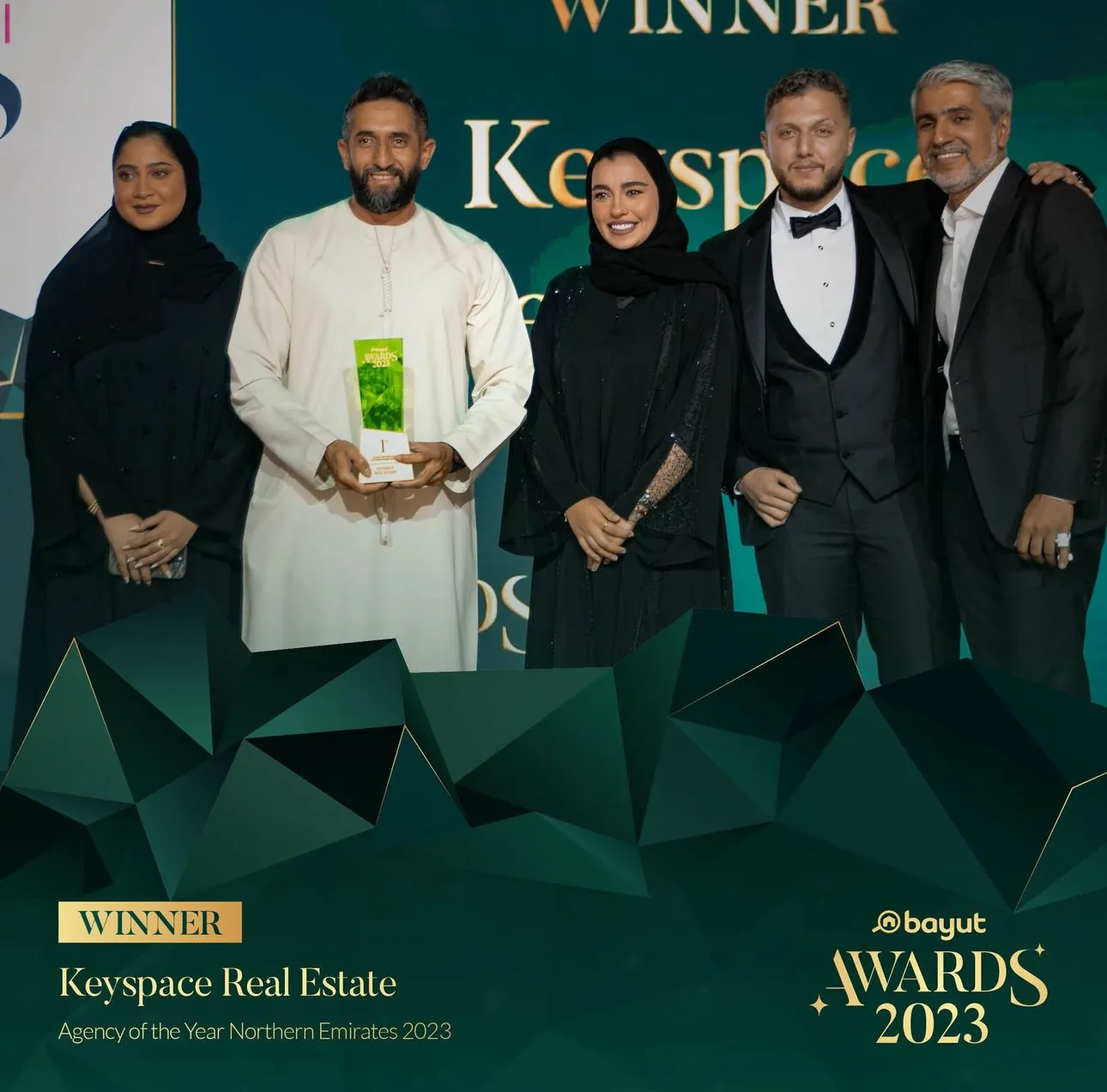 A Keyspace team member receiving an award on stage under warm spotlight